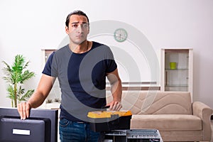 Young man repairing computer at home