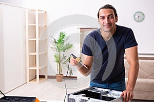 Young man repairing computer at home