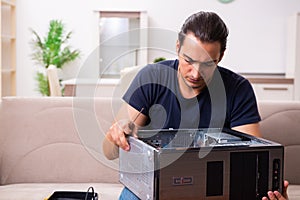 Young man repairing computer at home