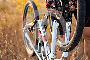 Young man repairing mountain bike in the forest