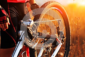 Young man repairing mountain bike in the forest