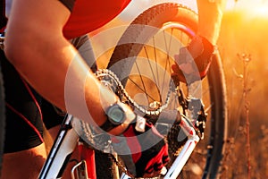 Young man repairing mountain bike in the forest