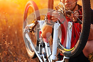 Young man repairing mountain bike in the forest