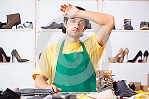 The young man repairing shoes in workshop