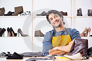 The young man repairing shoes in workshop