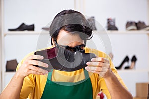 The young man repairing shoes in workshop