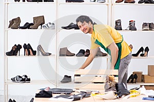 The young man repairing shoes in workshop