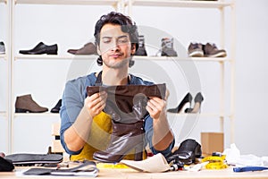 The young man repairing shoes in workshop