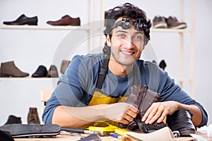 The young man repairing shoes in workshop