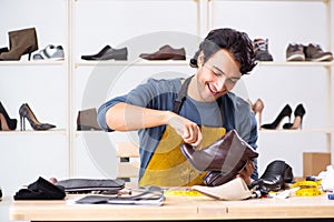 The young man repairing shoes in workshop