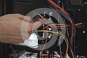 Young man repairs a computer system unit, changes parts, video card and hard drive, sets new components. Computer Repair