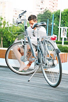 Young man resting in the city with bicycle