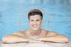 Young Man Resting On Edge Of Swimming Pool