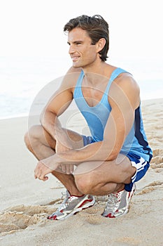 Young Man Resting After Exercise On Beach