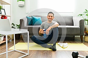 Young man resting on an exercise mat in the living room