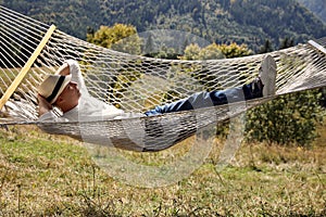 Young man resting in hammock outdoors on sunny day