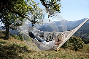 Young man resting in hammock outdoors on sunny day