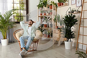 Young man resting in room with home plants