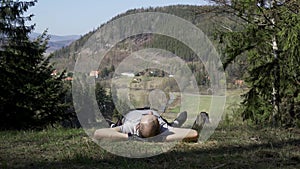 A young man resting after work lying in a meadow