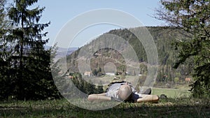 A young man resting after work lying in a meadow