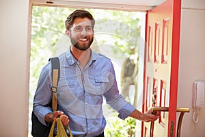 Young Man Returning Home For Work With Shopping
