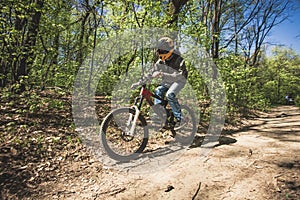 Young man ride mountain bike through forest