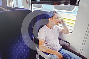 Young man rides a train, looks out the window, travel, comfortable trip trip