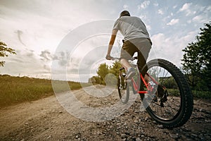 Young man riding bicycle along a country road