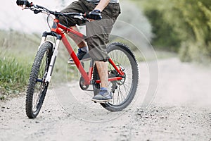 Young man riding bicycle along dusty country road