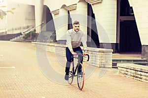 Young man riding bicycle on city street