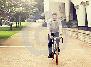 Young man riding bicycle on city street