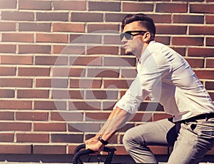 Young man riding bicycle on city street