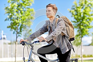 Young man riding bicycle on city street