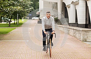 Young man riding bicycle on city street