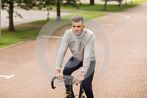 Young man riding bicycle on city street