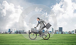 Young man riding bicycle on green grass