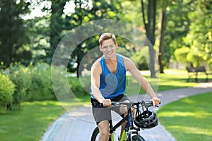 Young man riding bicycle in park