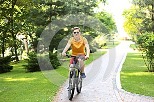 Young man riding bicycle in park