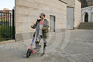 Young man riding an electric scooter with view on the city