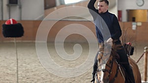 Young man riding his horse and swinging his sword. A Cossack horseman cuts through a Cossack hat.