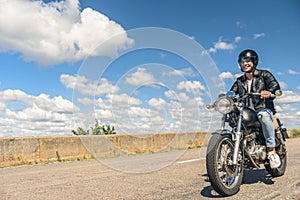 Young man riding his motorbike on open road