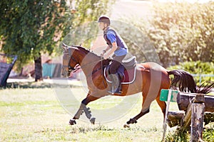 Young man riding horse on cross-country course