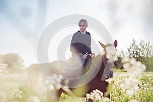Young man riding a horse in the field