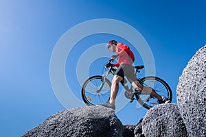 Young man riding mountain bike on the background of mountains