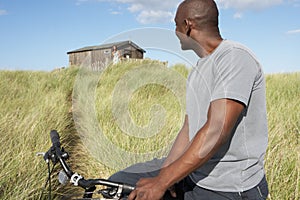 Young Man Riding Mountain Bike By Dunes