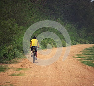 young man riding mountain bike in dusty road use for sport leisure and healthy activities