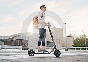 Young man, riding scooter and eco friendly for emission free future, sustainable and outdoor. Travel, casual business
