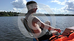 A young man riding a water bike and laughs