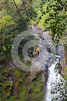 A young man riding on a zip line rope in an extreme adventure jungle in Xico, Veracruz, Mexico photo
