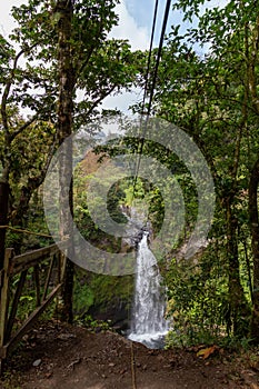 A young man riding on a zip line rope in an extreme adventure jungle in Xico, Veracruz, Mexico photo